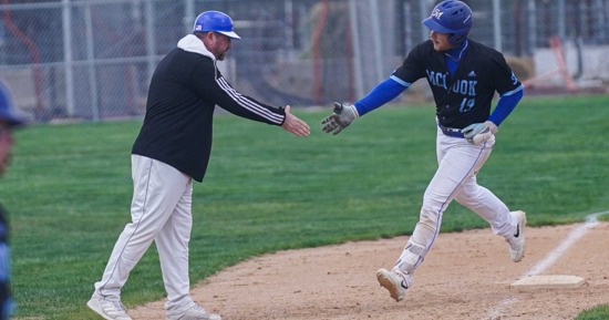 Sophomore Cory Wouters rounds third base after hitting his 20th home run of the year, congratulated by Coach Jon Olsen. Wouters set a school RBI record with 94 and leads the MCC offense into the Region IX post-season tournament starting Thursday.